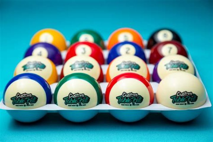 Brew whose red-and-white logo was inspired by billiard balls Crossword Clue